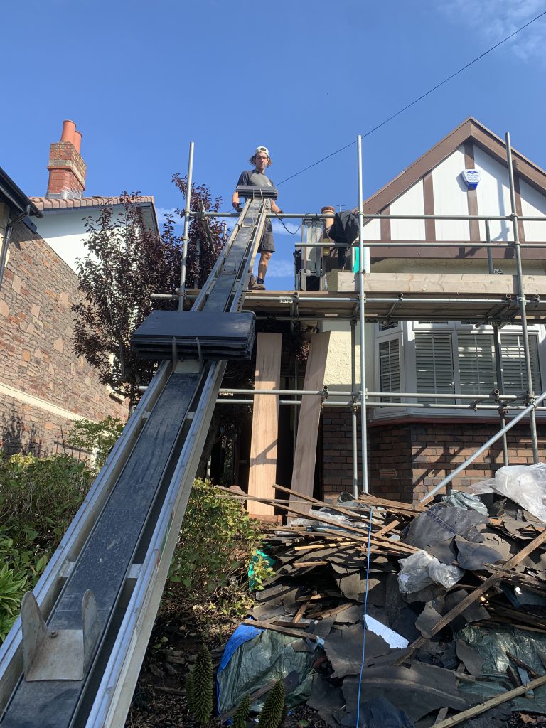 Worker with tile conveyor during a strip, Brislington, Albion Roofing.